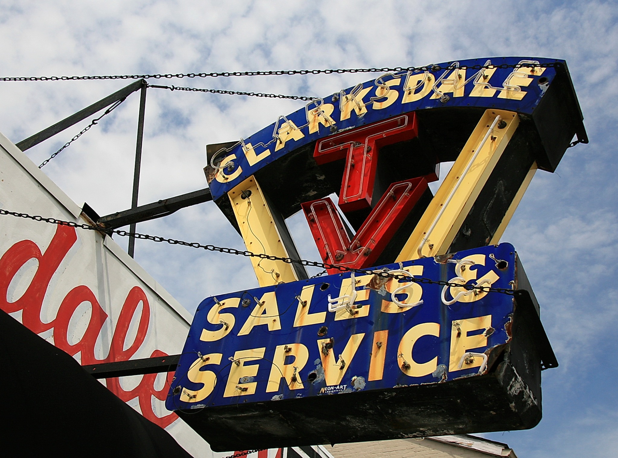 The blue, red and gold Clarksdale TV Sales & Service sign above the Louisville shop